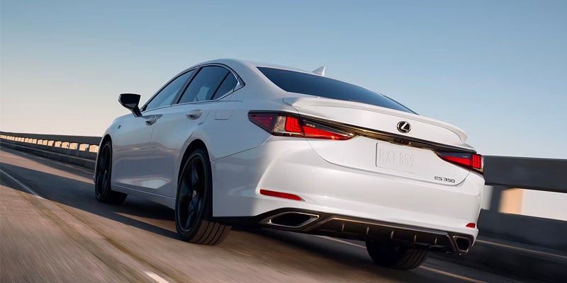 A photo of a white 2024 Lexus ES driving down a highway