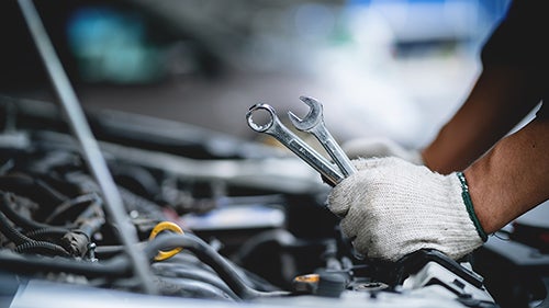 Auto Mechanic Working on Engine
